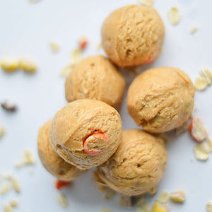 Protein bites scattered on a table with reeses's pieces