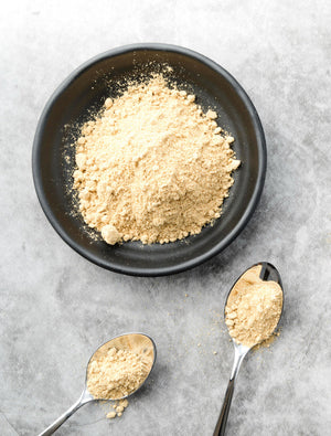 Bowl of organic protein powder with two spoons